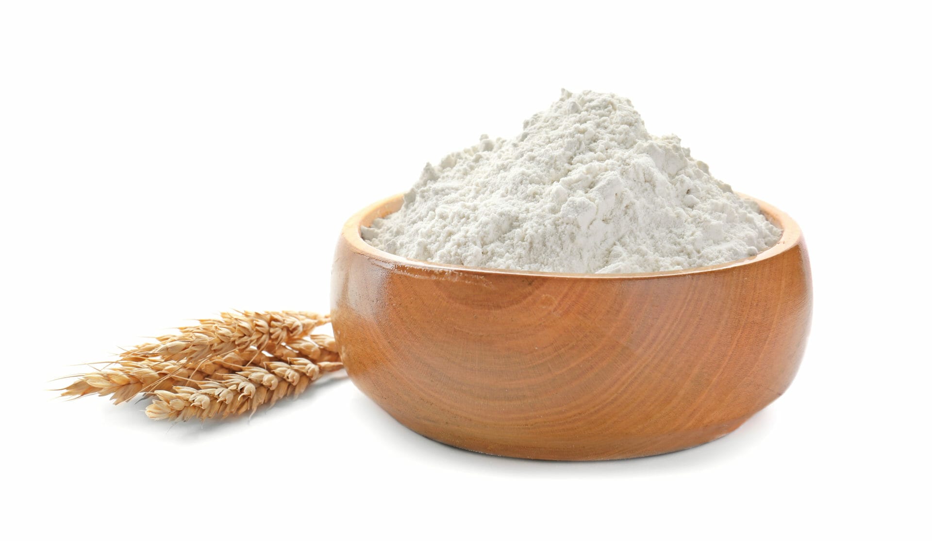 Bowl with wheat flour and spikelets on white background