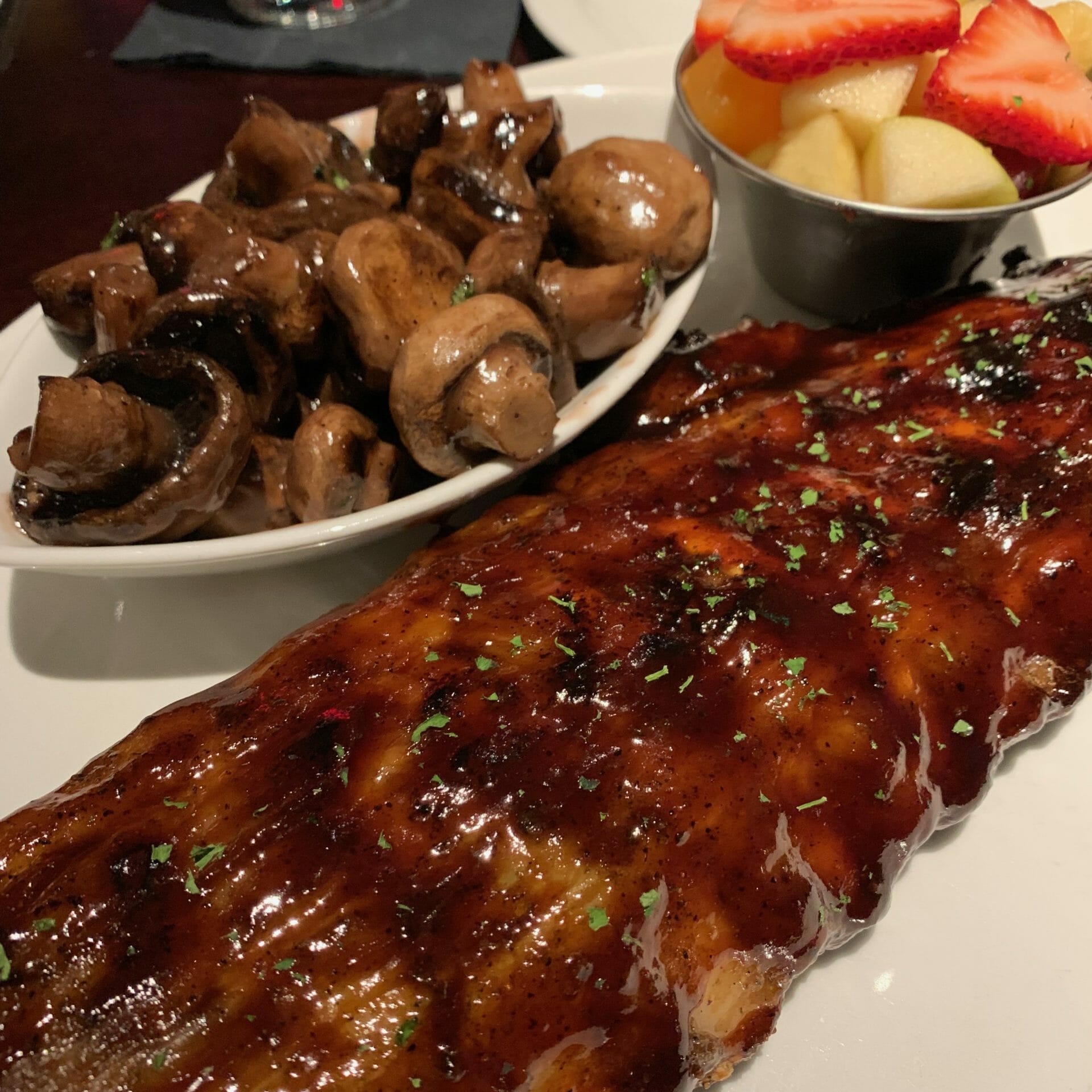 Ribs with a sauce that had way too much sugar, sautéed mushrooms and fresh fruit (Firebird Grill)