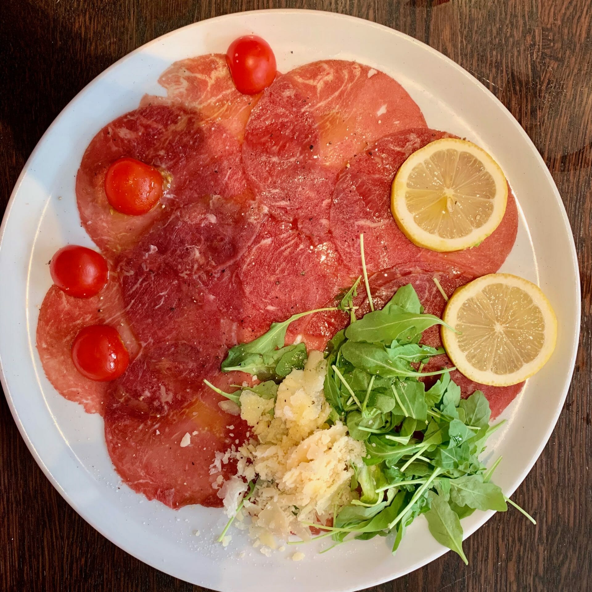 Beef carpaccio with tomatoes, parmesan and lettuce
