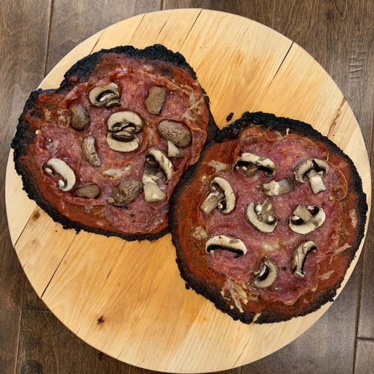 Cauliflower pizza crust with tomato sauce, uncured salami, goat cheese and mushrooms