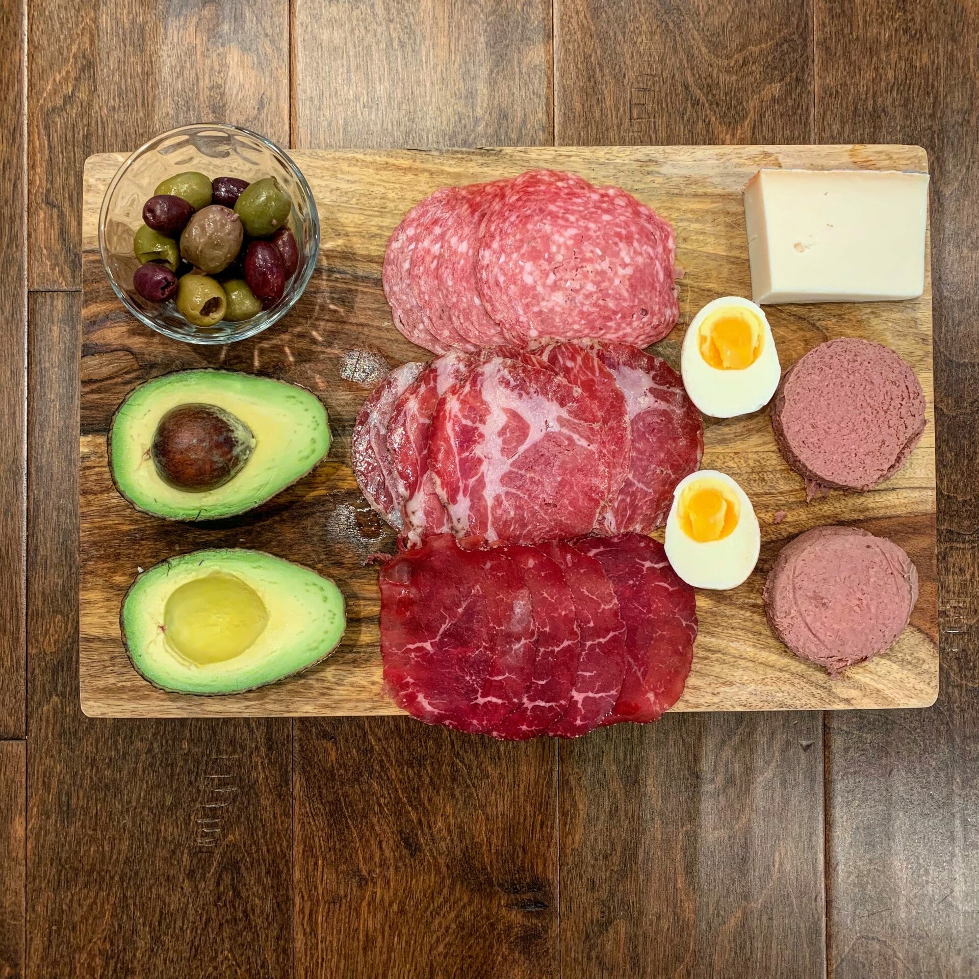 Dinner plate with uncured cold cuts, avocado, olives, goat cheese, boiled egg and pastured liverwurst