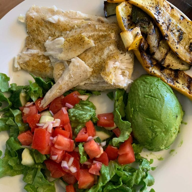 Steamed fish with grilled zucchini, avocado, lettuce, tomatoes, cucumber and onions