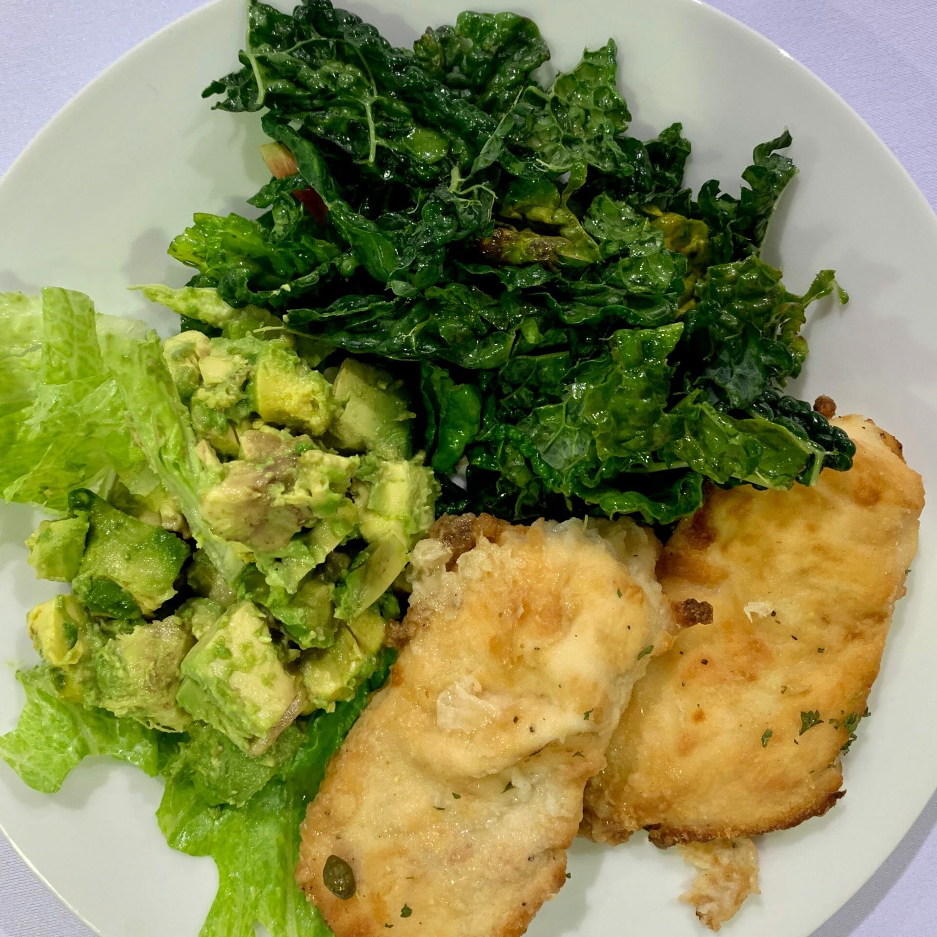 Fried fish with kale, lettuce and avocado