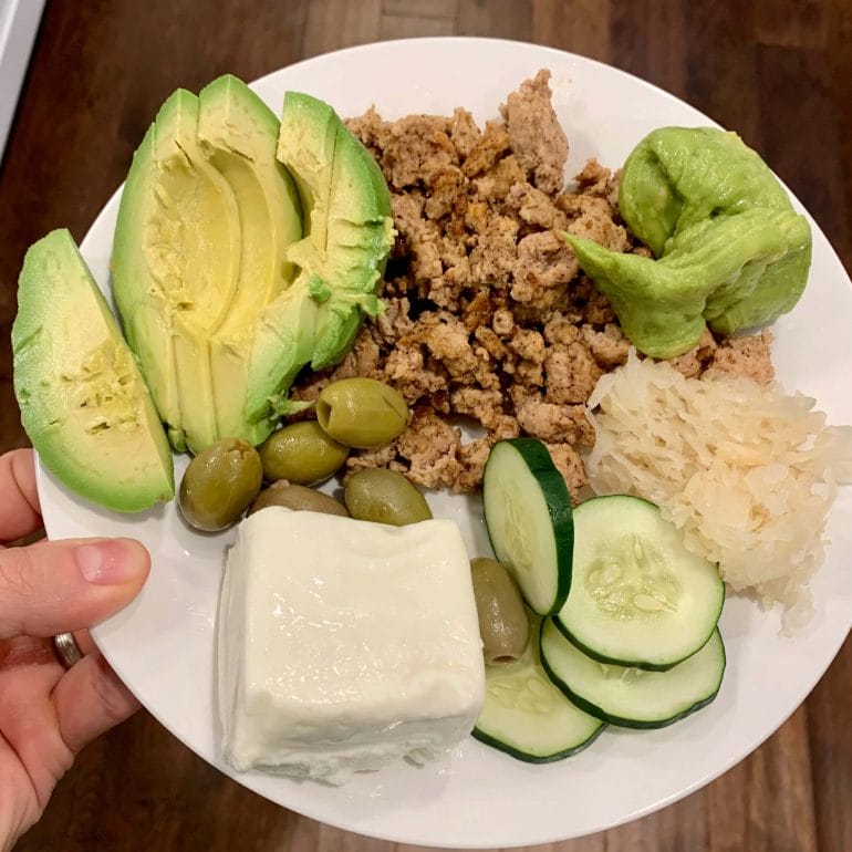Ground turkey with sliced avocado, olives, guacamole, goat cheese, cucumber and sauerkraut