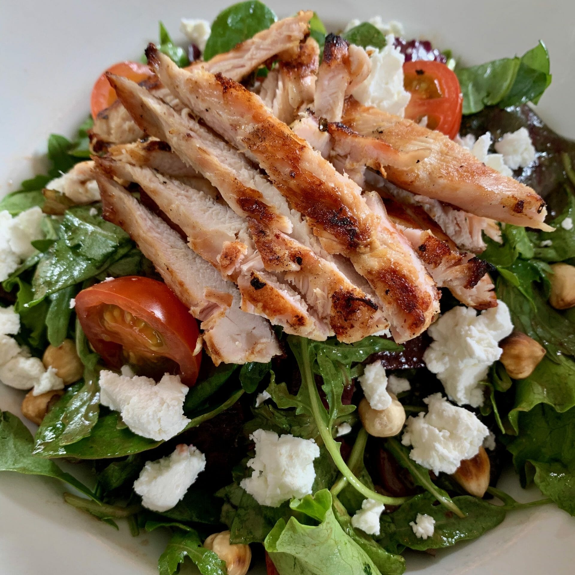 Mixed salad with grill chicken strips, goat cheese, hazelnuts, beets and tomatoes