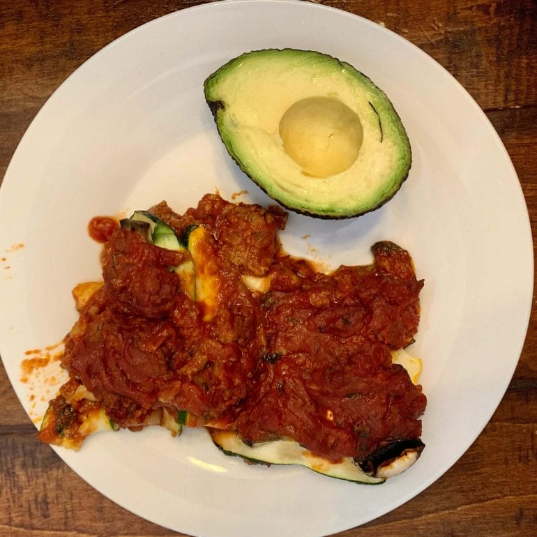Paleo lasagne with zucchini, ground meat, tomato sauce and avocado