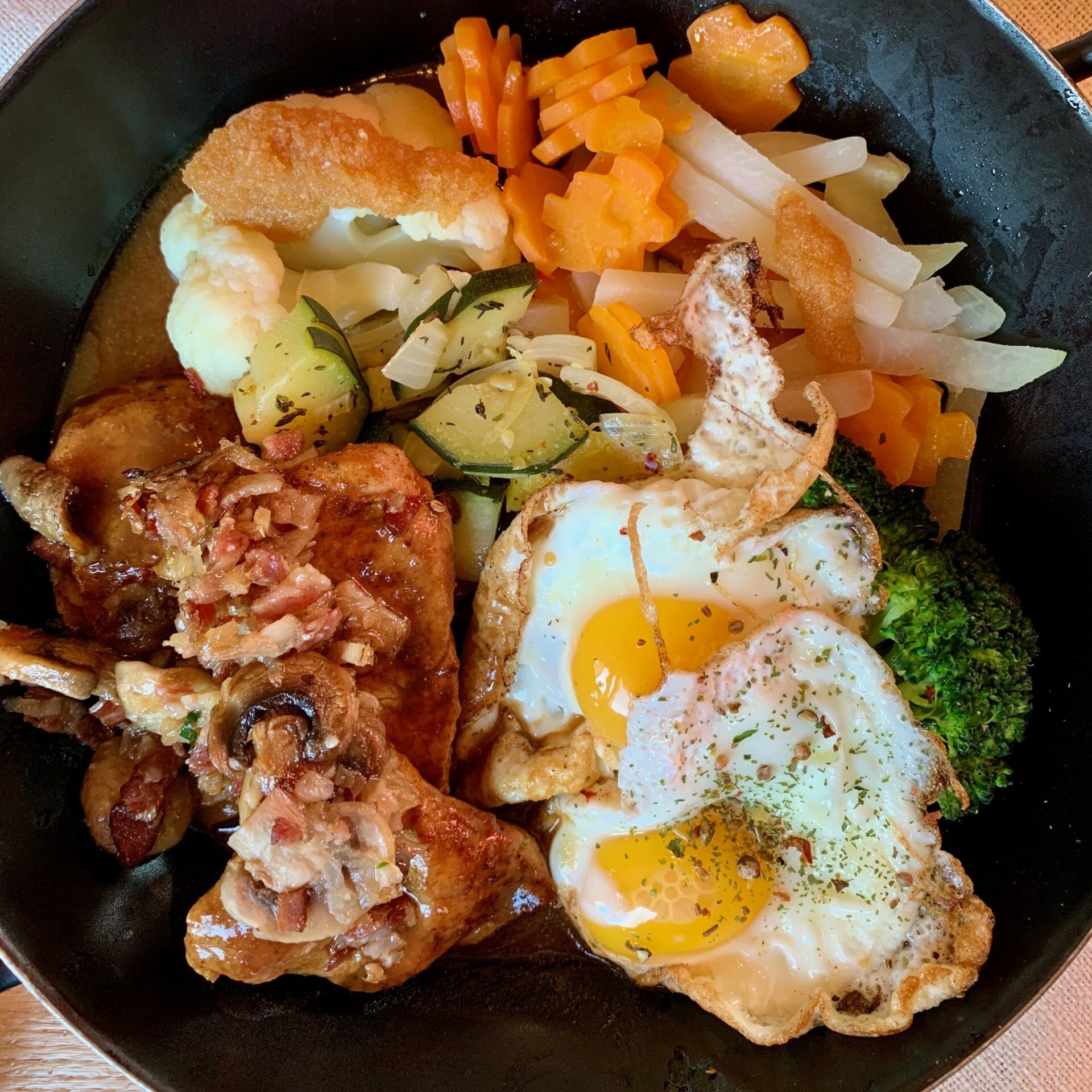 Port with fried eggs, carrots, bacon, broccoli and zucchini