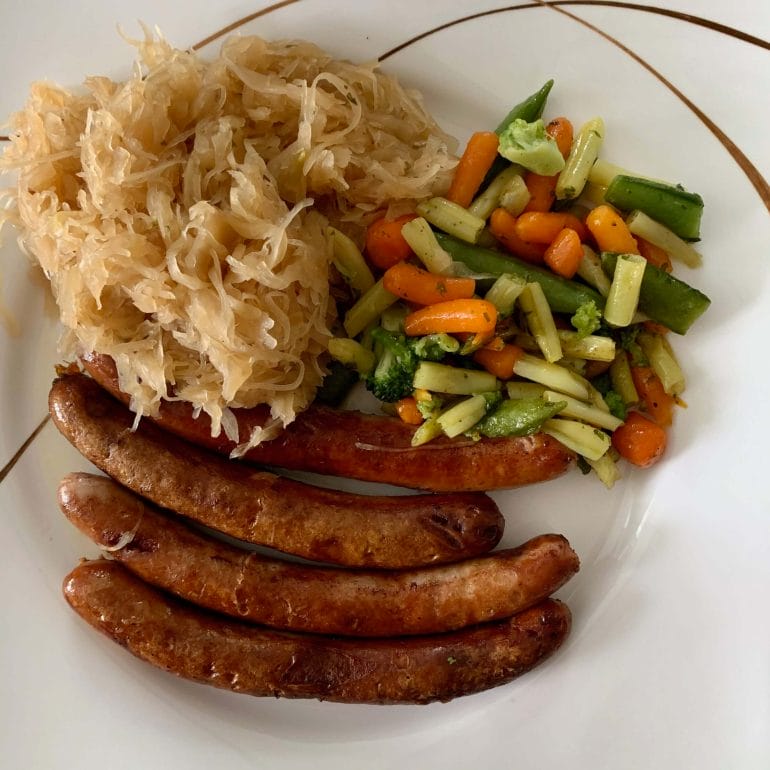 Port sausages with sauerkraut, carrots, green beans and broccoli