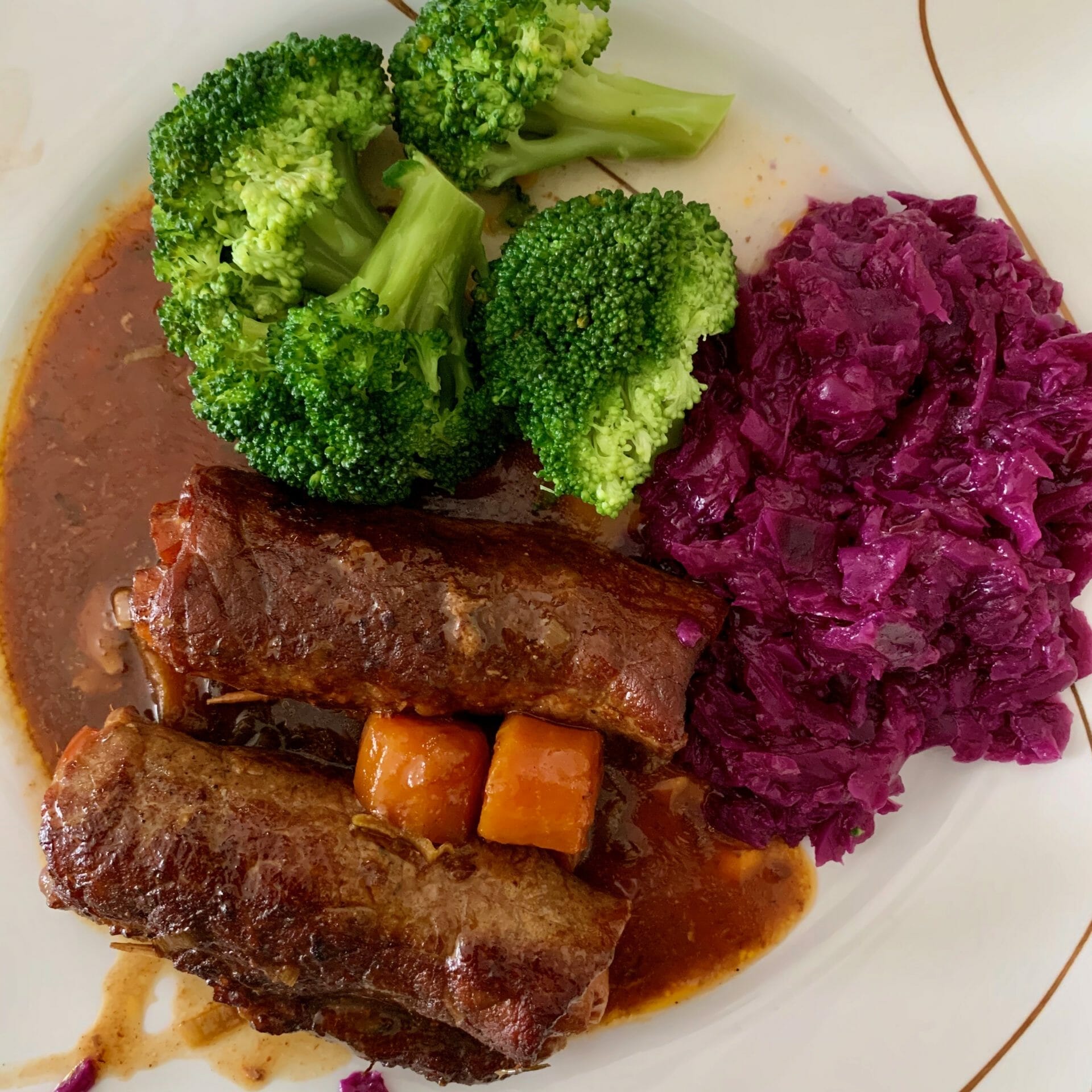 Beef stuffed with carrots and bacon, red cabbage and broccoli