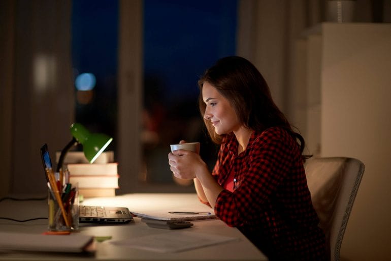 Woman drinking coffee at night