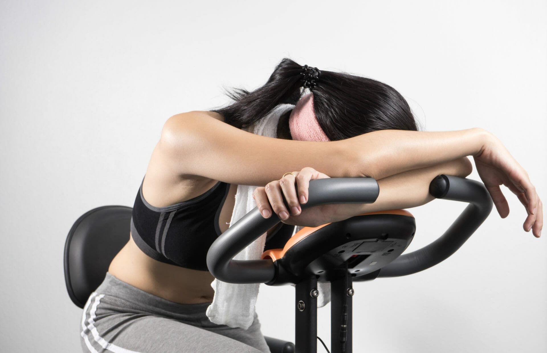 Woman exhausted and sleepy on an exercise bike