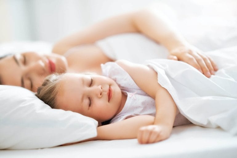 Woman sharing a bed with toddler