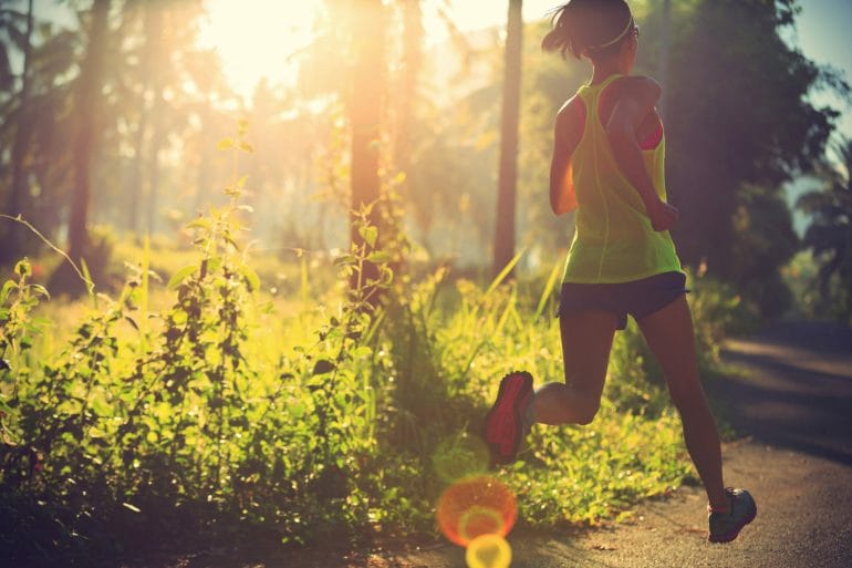 Woman running through wooded area