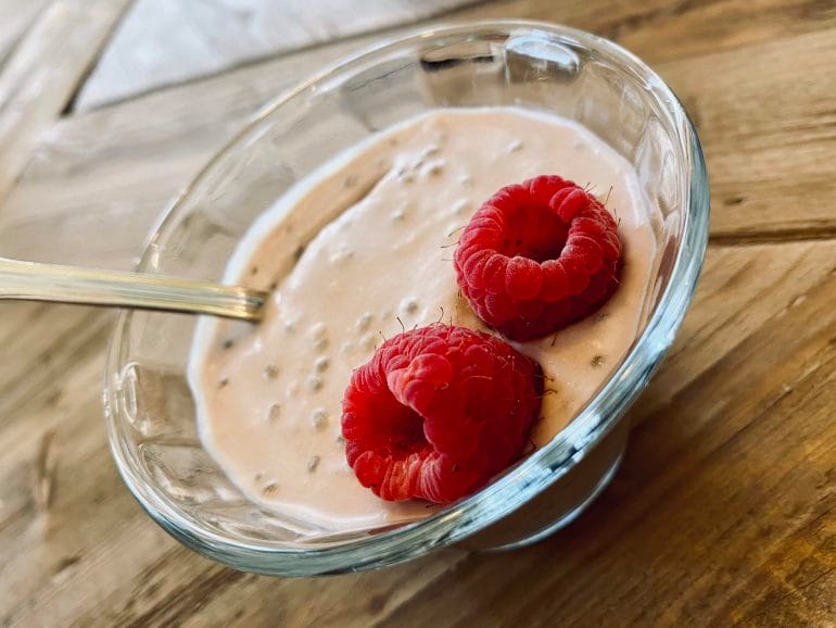 Keto coconut chia pudding with cacao and raspberries.