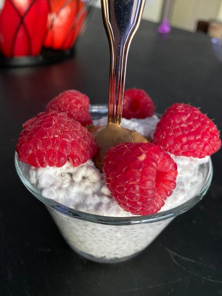 Keto coconut milk chia pudding with almond butter and raspberries.
