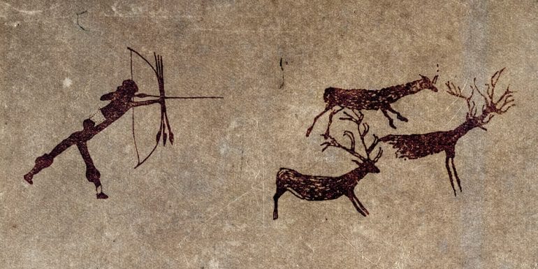 Cave drawing of human hunting animal