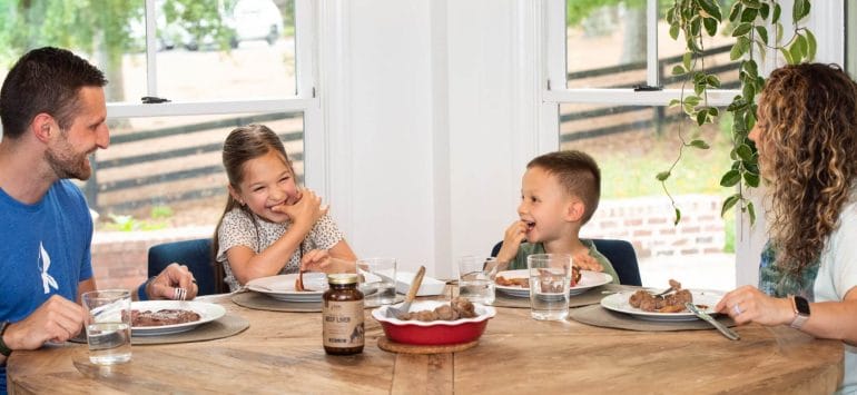 A photo showing the Kummer family happily eating together at the dinner table.