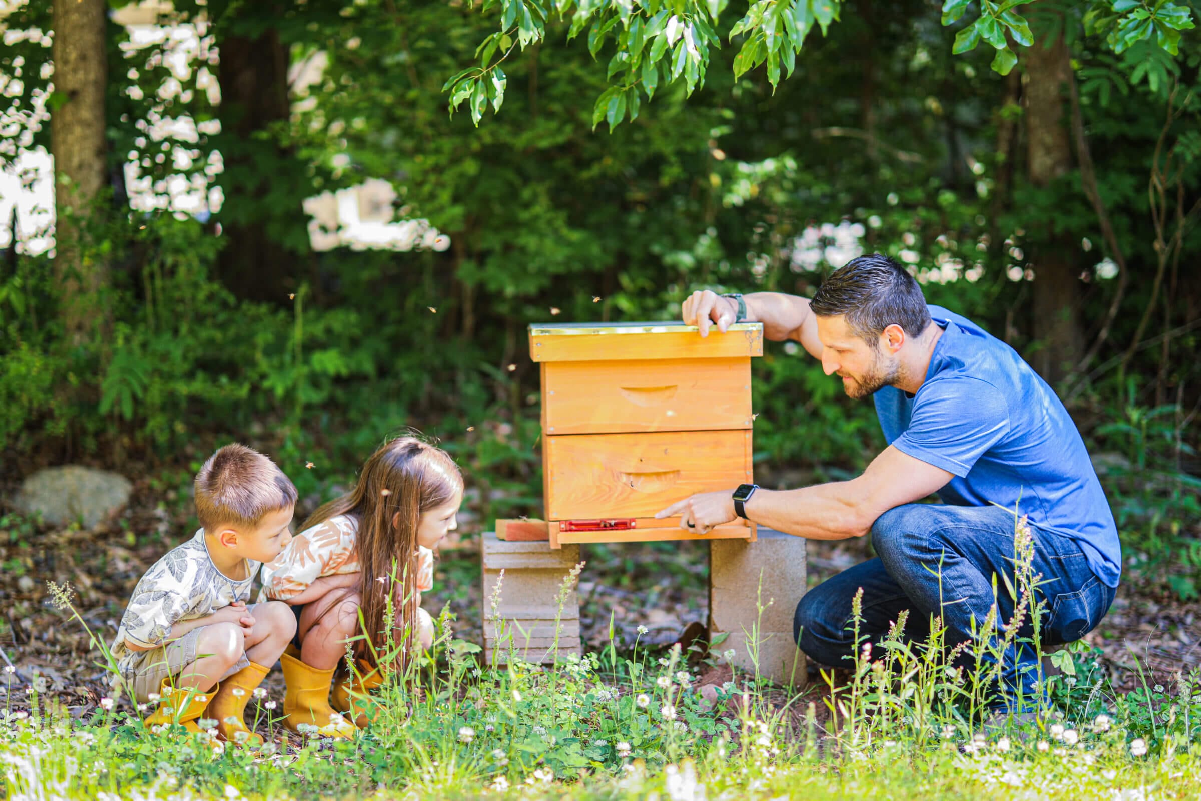 Michael Kummer with his two children and one of their beehives.