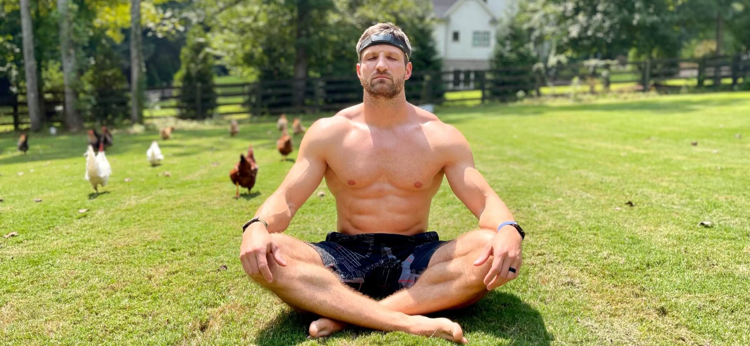 Michael Kummer sitting in the backyard meditating, wearing Muse S, with chickens in the background.