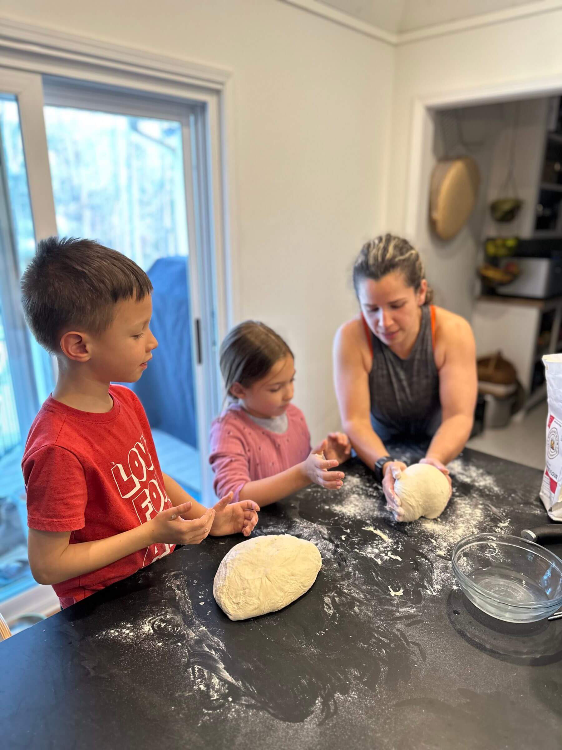 Kathy teaching the kids how to fold sourdough to make pizza crust.