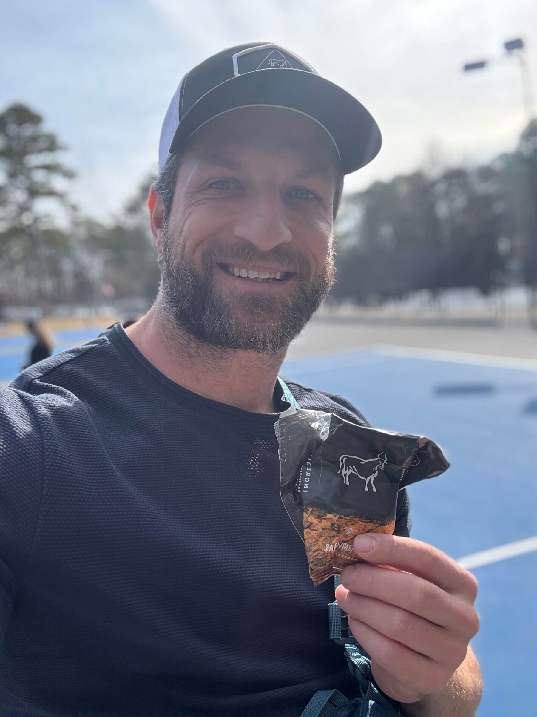 Michael eating a carnivore bar while playing pickleball