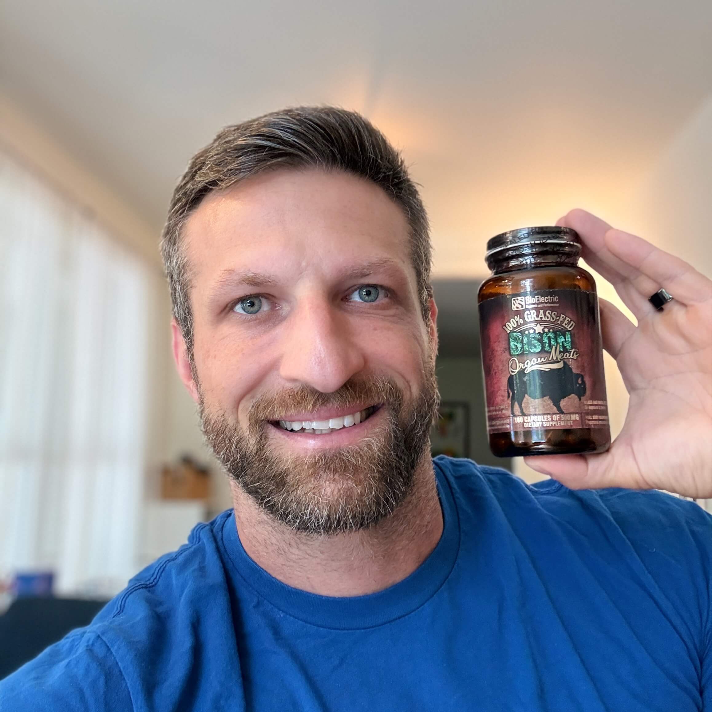 Michael Kummer holding a bottle of BioElectric bison organs supplement.