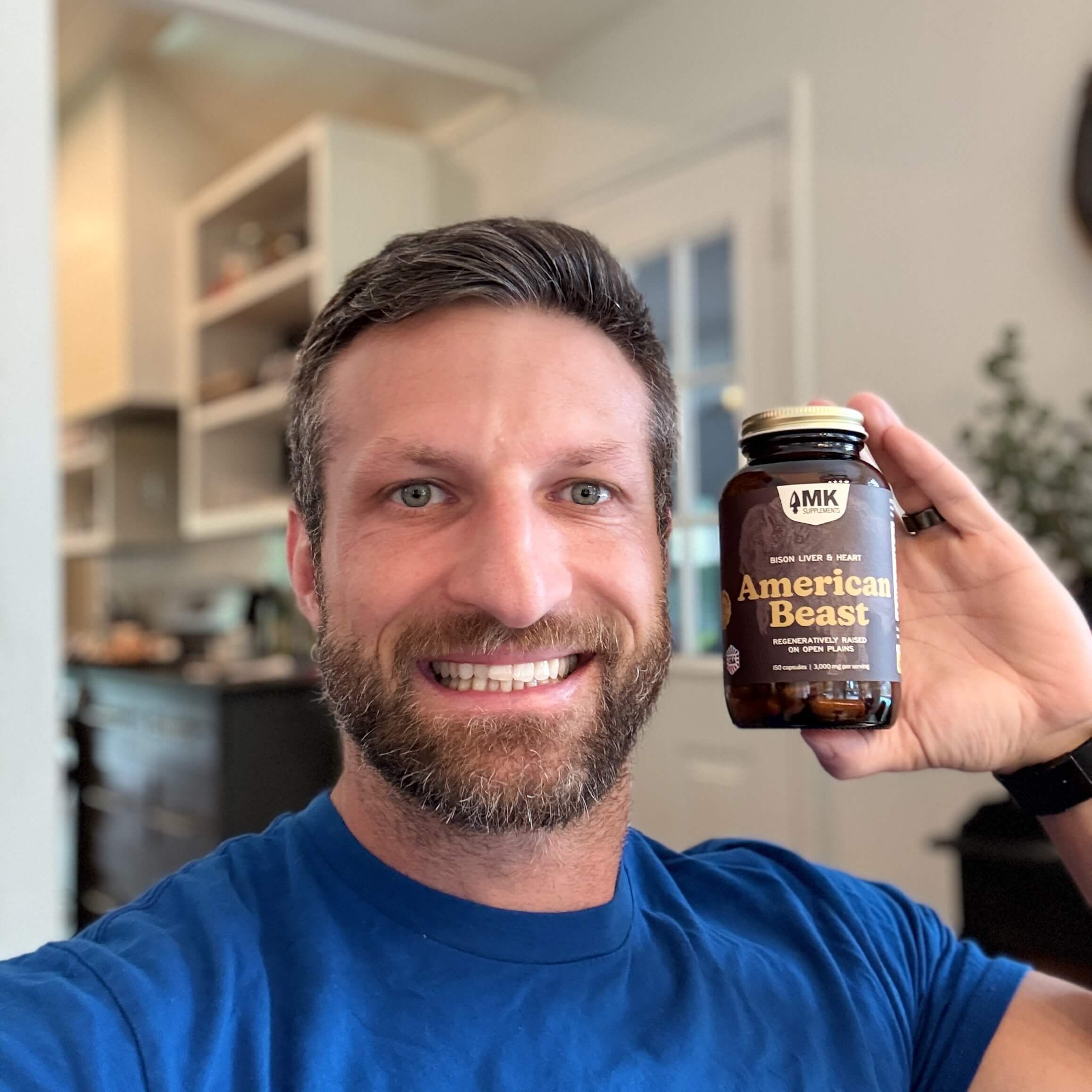 Michael Kummer holding a bottle of American Beast bison organs supplement.