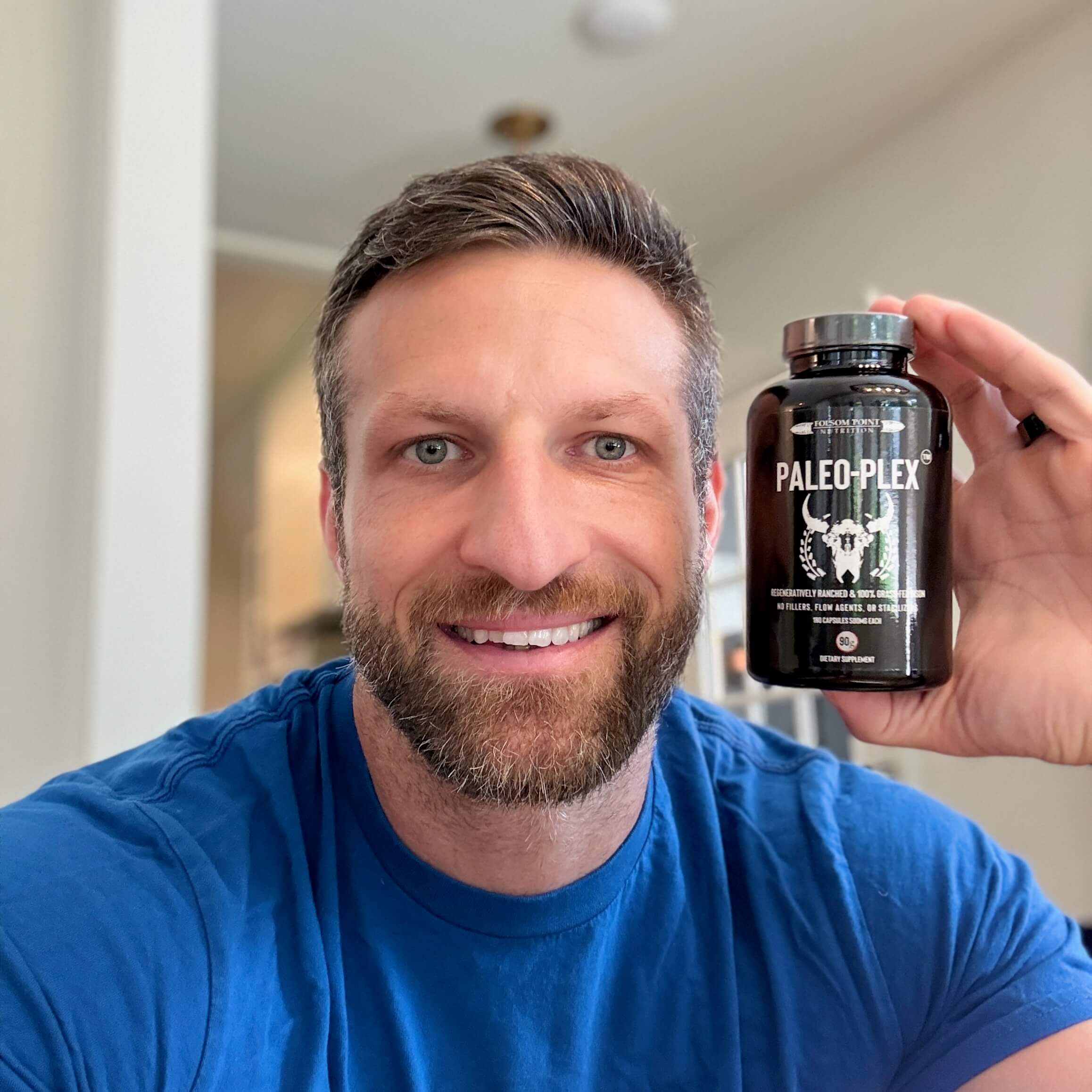 Michael Kummer holding a bottle of Paleo-Plex bison organ supplement.